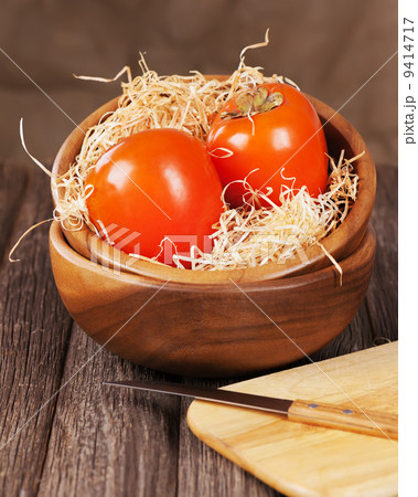 Fresh ripe persimmon in bowl on wooden table. 9414717