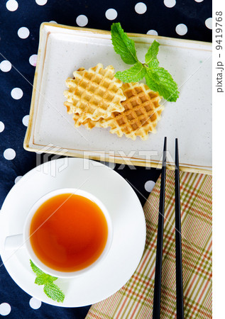 Top view of Tea with waffle and chopsticks in ceramic plate Top view of Tea with waffle and chopsticks in ceramic plate 9419768