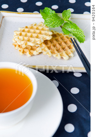 Tea with waffle and chopsticks in ceramic plate 9420164