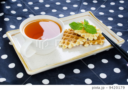 Tea with waffle and chopsticks in ceramic plate 9420179