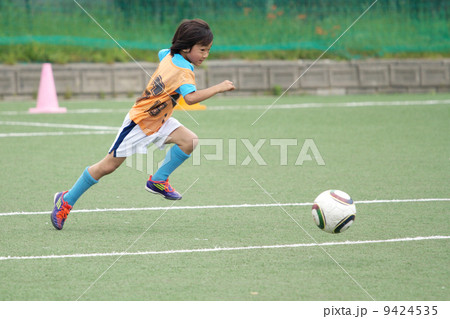 ユニフォームを着たサッカー少年のドリブルシーン 9424535