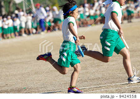 小学校運動会での白熱したリレー 9424558