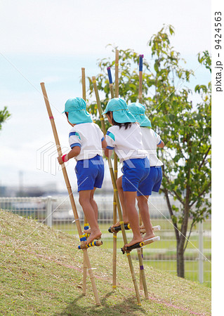 幼稚園の運動会で竹馬を披露する子供達の写真素材