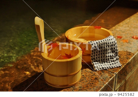 秋冬の素材・温泉の夜、湯桶の中にモミジの葉・横位置 9425582