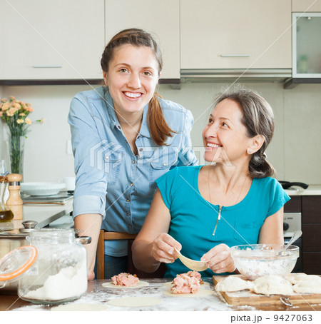 women making pies or meat dumplings together 9427063