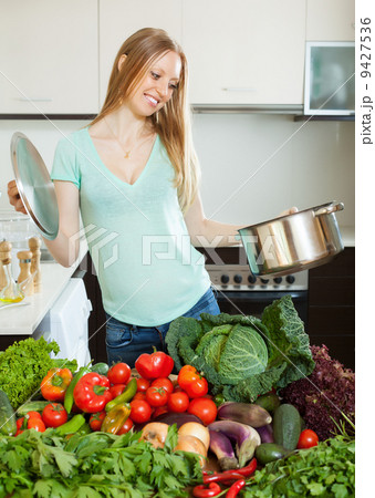 happy woman cooking with pan and vegetables 9427536