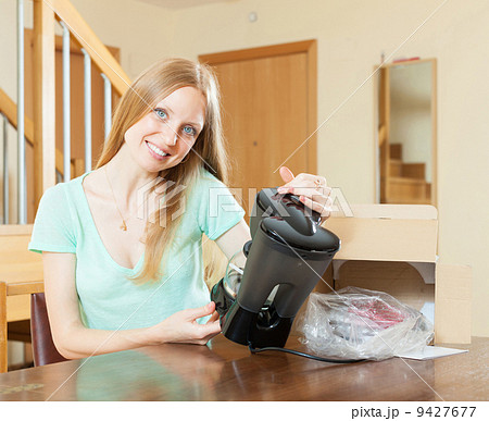 woman reading warranty card for new coffee machine at home int 9427677
