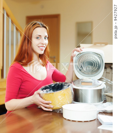Young woman with electric slo-cooker Young woman with electric slo-cooker 9427927