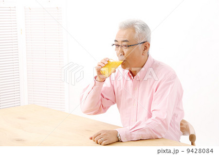 オレンジジュースを飲むシニア男性 9428084