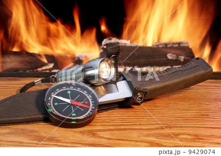 Compass, a hunting knife and a handheld flashlight around the ca 9429074
