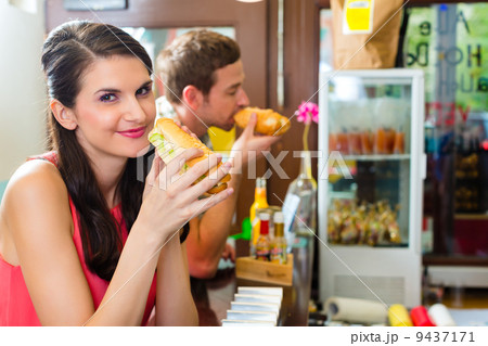 Customers eating Hotdog in fast food snack bar 9437171