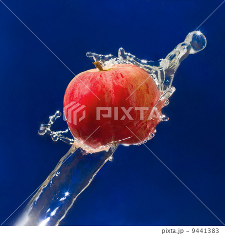 Red Apple drops in the jet of blue water sprays on texture Red Apple drops in the jet of blue water sprays on texture 9441383