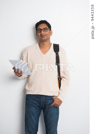 casual indian male student on a sweater and tablet casual indian male student on a sweater and tablet 9443359