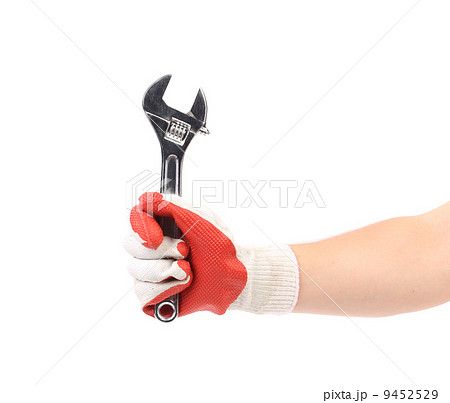 Hand in gloves holding wrench. 9452529