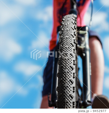 Mountain Bike and blue sky background. Focus on the front wheel. Mountain Bike and blue sky background. Focus on the front wheel. 9452977