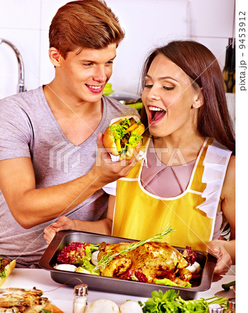 Couple cooking chicken at kitchen. Couple cooking chicken at kitchen. 9453912