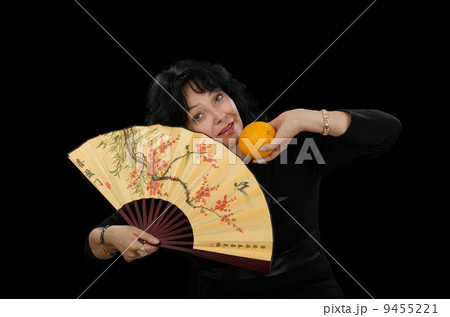 Mature actress with a fan and orange Mature actress with a fan and orange 9455221