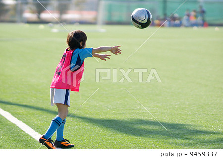 ユニフォームを着たサッカー少年のスローインの写真素材