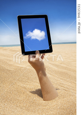 hand holding touch screen computer on the beach hand holding touch screen computer on the beach 9463531
