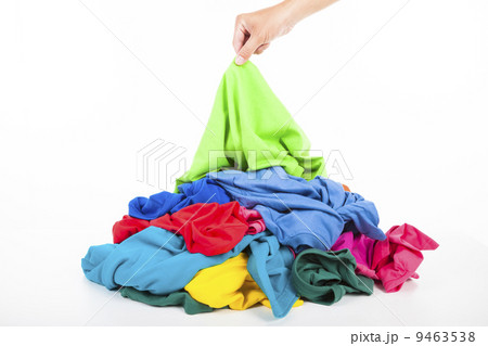hand pick up a shirt in pile of colorful clothes 9463538