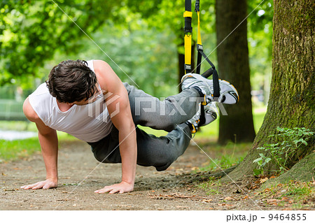 man in city park doing suspension trainer sport man in city park doing suspension trainer sport 9464855