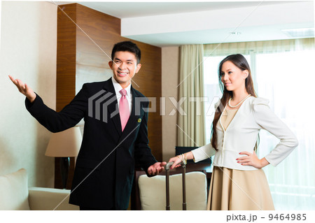 Asian Chinese hotel manager presenting suite 9464985