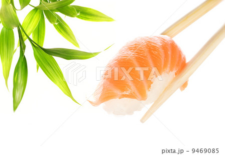 Wooden chopsticks holding salmon sashimi 9469085