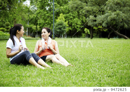 Two friends talking after exercising in the park Two friends talking after exercising in the park 9472625