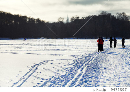 skiers and walking people on snowy field 9475397