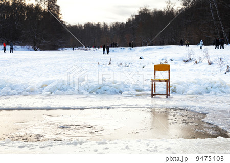 icebound chair near opening water in frozen lake icebound chair near opening water in frozen lake 9475403