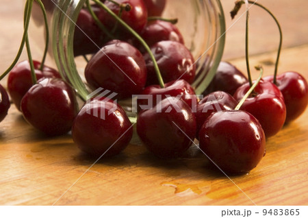 Cherry in glass jar isolated on the wooden background Cherry in glass jar isolated on the wooden background 9483865