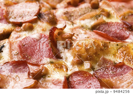 Italian pizza with bacon, salami and mozzarella cheese Italian pizza with bacon, salami and mozzarella cheese 9484256