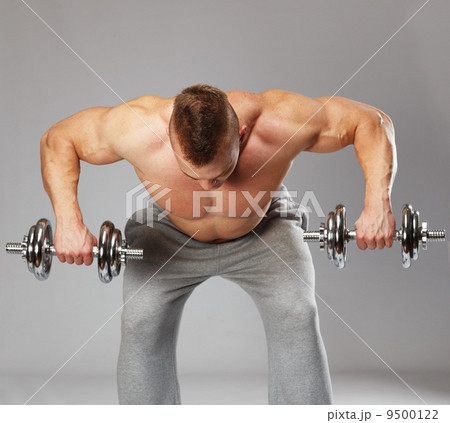 Handsome young muscular man exercising with dumbbells Handsome young muscular man exercising with dumbbells 9500122