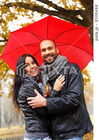 Happy middle-aged couple with umbrella outdoors on beautiful rainy autumn day Happy middle-aged couple with umbrella outdoors on beautiful rainy autumn day 9500488
