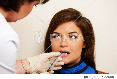 Dentist making x-ray picture of a happy female patient 9500800