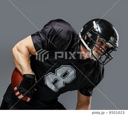 American football player with ball wearing helmet and jersey 9501023