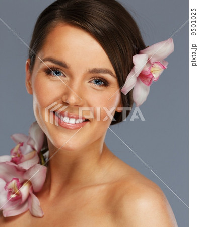 Young beautiful brunette woman with orchid flowers 9501025