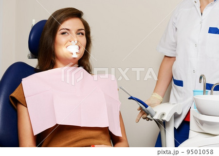 Dentist making teeth whitening procedure to woman patient Dentist making teeth whitening procedure to woman patient 9501058