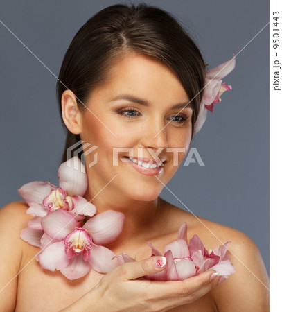 Young beautiful brunette woman with orchid flowers 9501443