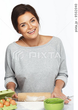 Young brunette woman with rolling pin preparing dough 9502040
