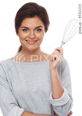 Young woman with a whisk isolated on white background Young woman with a whisk isolated on white background 9502233