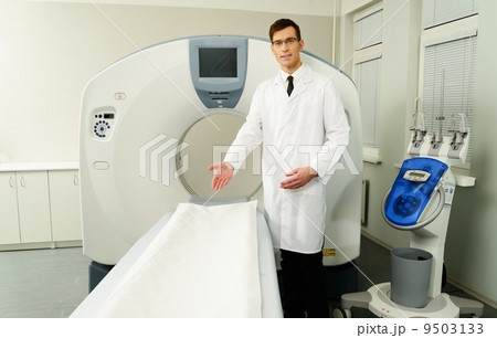 Young doctor standing near computed tomography scanner in a hospital 9503133