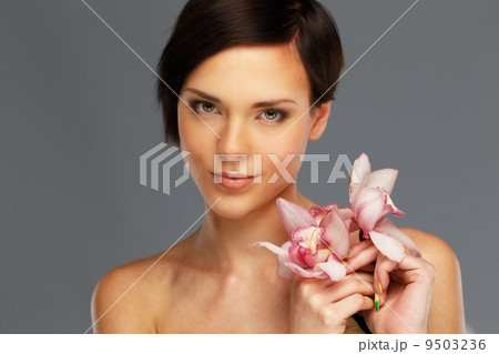 Young beautiful brunette woman with orchid flowers 9503236