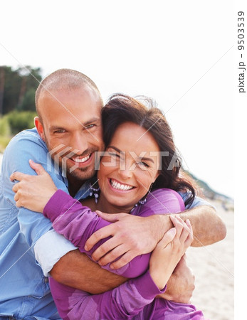 Happy smiling middle-aged couple on a beach 9503539