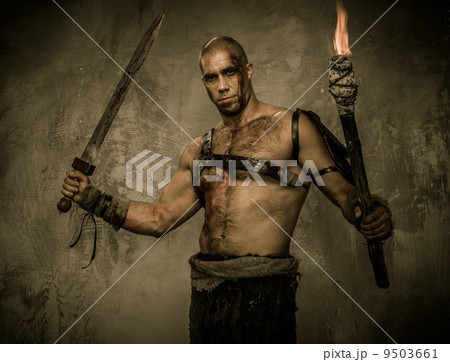 Wounded gladiator holding torch and sword covered in blood 9503661