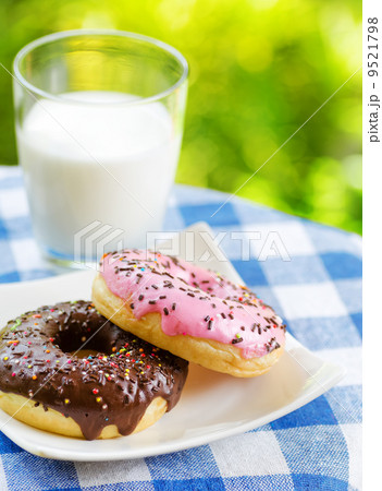 Fresh donuts and glass of milk on nature background Fresh donuts and glass of milk on nature background 9521798