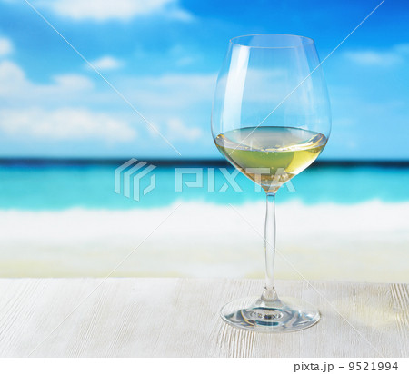 Glass of wine on beach background Glass of wine on beach background 9521994