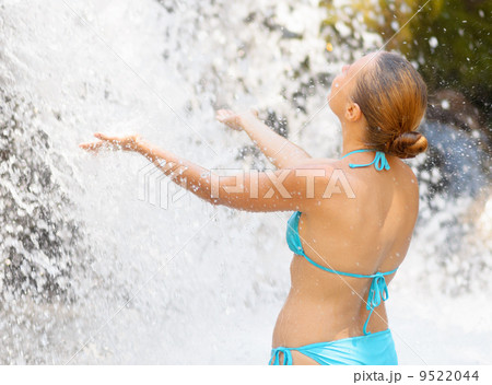 Young woman relaxing in waterfall Young woman relaxing in waterfall 9522044