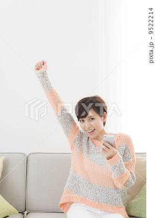 ネット検索　ソファーに腰かけてスマートフォンで検索をする女性 9522214