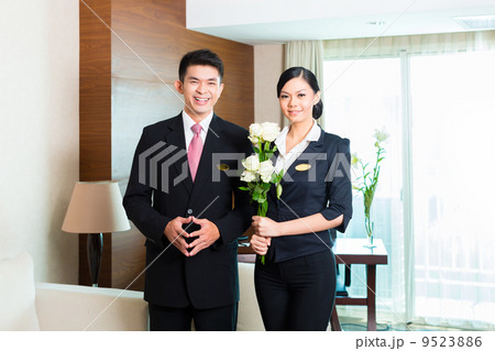 Asian Chinese hotel manager welcoming VIP guests 9523886